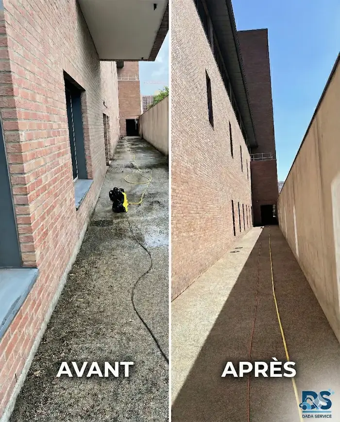 Allée extérieure le long d’un bâtiment en brique, nettoyée au nettoyeur haute pression.